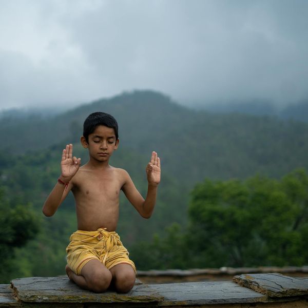 Person meditating peacefully outdoors with a serene natural background.